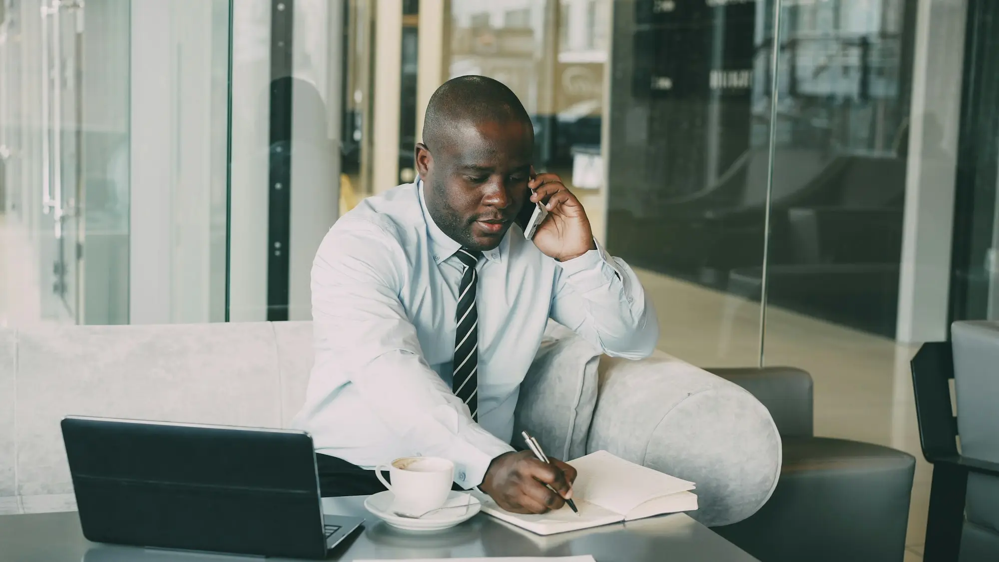 Adviser making notes at his desk during a call