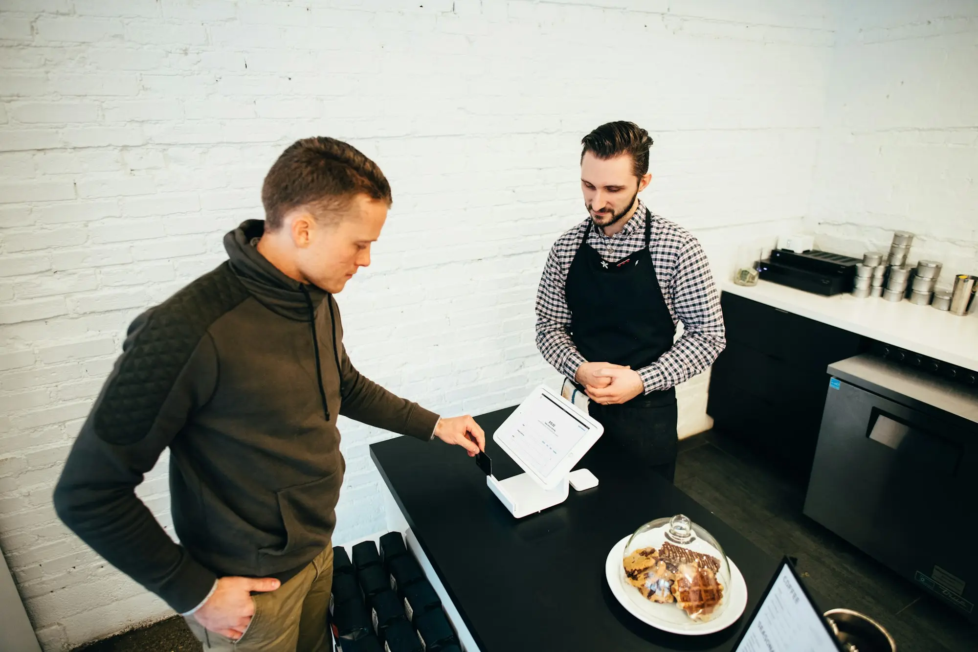 Bakery owner going over a supplier invoice with a colleague