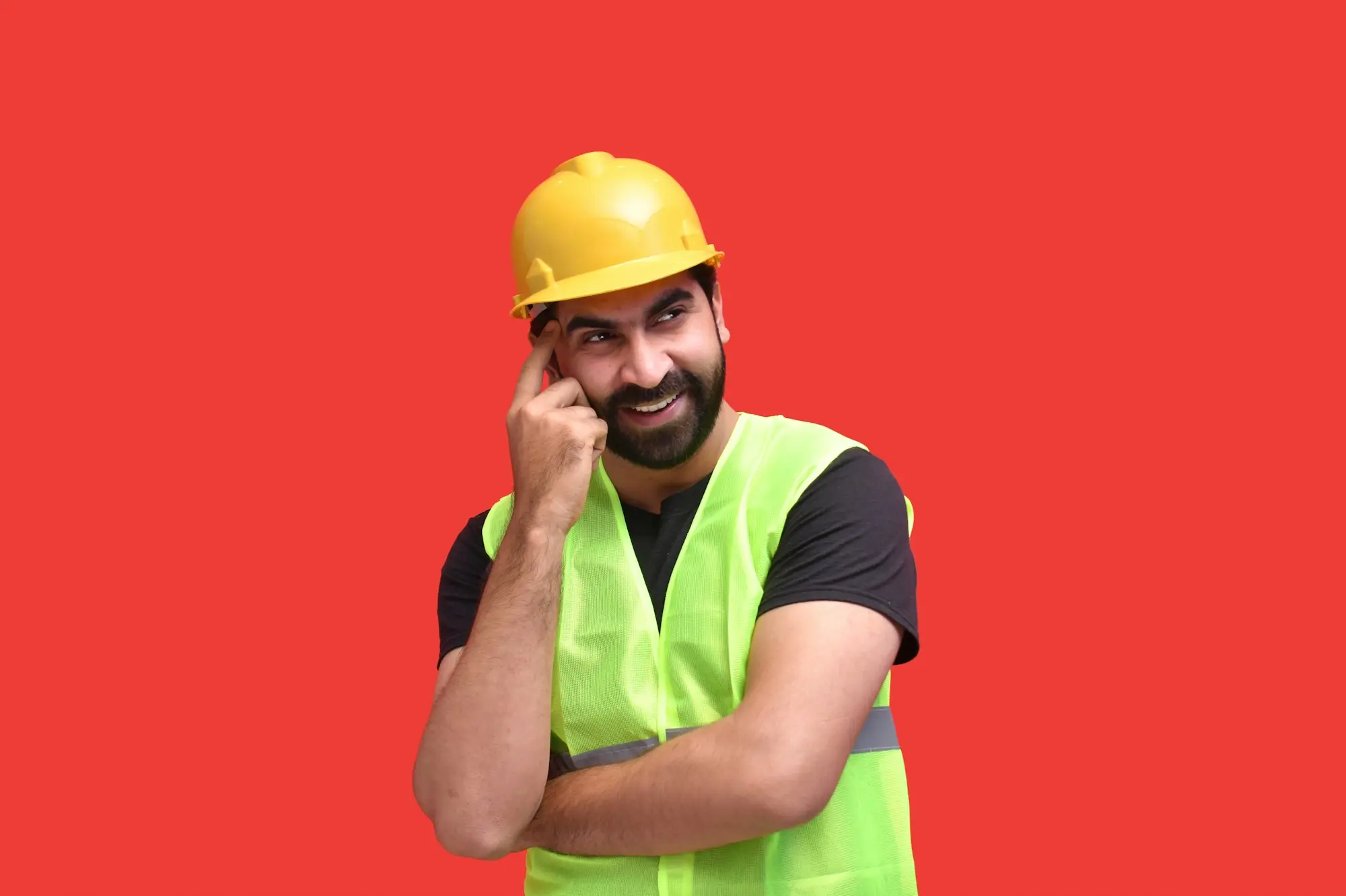 Builder in a hard hat and hi-vis on a phone call